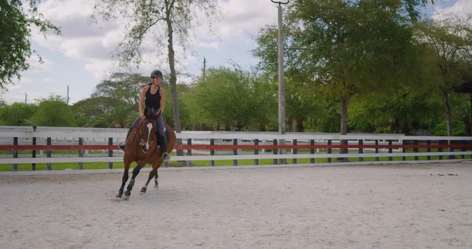 Girl horseback riding in equestrian course