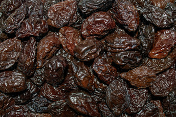 Background made of prunes. Fresh black dried prunes backdrop. Pile of dried prunes. Top view