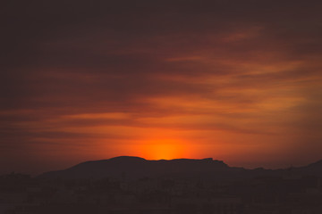 Sun goes behind the mountain in a sunset