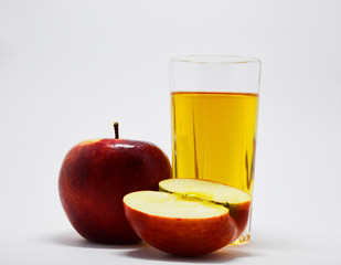 
red, ripe apples and a glass of apple juice on a white background. apples are a source of vitamins and iron during quarantine and self-isolation