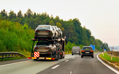 Fototapeta na wymiar Cars carrier truck in asphalt highway road in Poland reflex