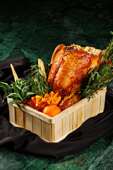 Roasted whole duck in a basket decorated with fresh thymes, basil, cranberry, and mandarin black background perfect for thanksgiving and special occasions. Food photography for magazine content. - 340067909
