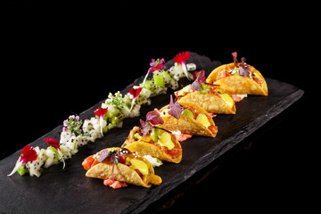 Variety flavors of mini tacos with dragon fruits on the side. Best food presentation for magazine and Mexican cook book snack dish plating concept in a black background.