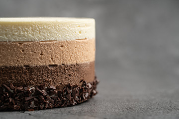 Cake with souffle milk chocolate cream on gray background. side view, close up, selective focus.