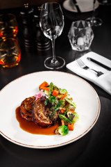 Healthy main course dish fro vegetarian. Eggplant with sauce and mixed tasty vegetables on the side. Food photography in fine dine in table background concept for cook book or magazine.