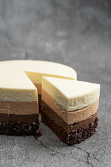 Cake with souffle milk chocolate cream on gray background. side view, close up, selective focus.