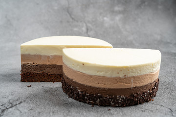 Cake with souffle milk chocolate cream on gray background. side view, close up, selective focus.