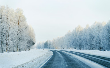 Obraz na płótnie Canvas Winter road and a Snowy Forest at Cold Finland reflex