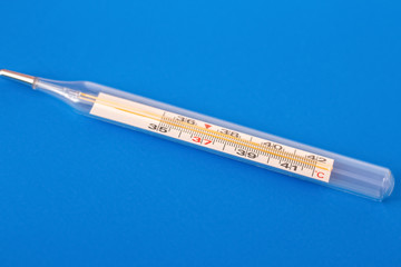 Mercury thermometer on a blue background