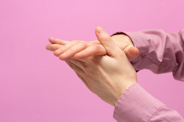 The guy rubs his hands. pink background