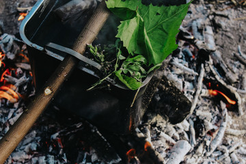 Tea in a cauldron on a fire in the forest (with mint)