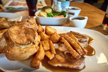 Traditional English Sunday roast lunch. National cuisine, roast potatoes, Yorkshire pudding and gravy    