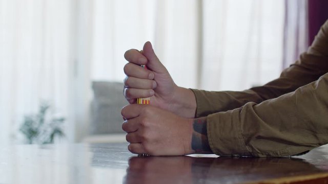 A young man throwing the wood sticks on the table before starting a pick up sticks game. Filmed in slow motion (60fps)