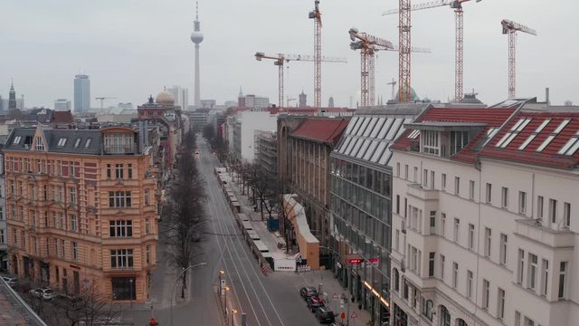 AERIAL: Slow flight trough Empty Central Berlin Neighbourhood Street with Cathedrals and view on Alexanderplatz TV Tower during Corona Virus COVID19 on Overcast Cloudy Day