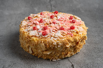 Round multi-layered cake Napoleon on gray concrete background. place for text. concept sweet-shop bakery