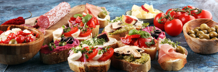 Assorted bruschetta with various toppings. Appetizing bruschetta or crudo crostini. Variety of small sandwiches. Mix bruschetta with tomatoes and basil