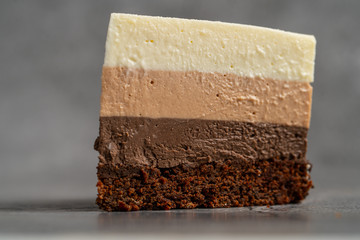 Cake with souffle milk chocolate cream on gray background. side view, close up, selective focus.