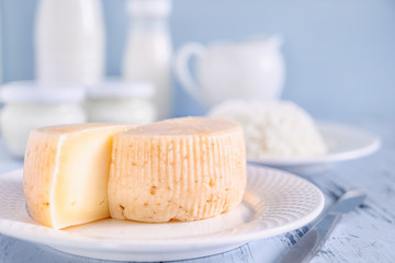 Sliced cheese close-up. In the background a set of dairy products. Copy space on a blue background.