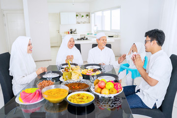 Little daughter praying before eat with her family