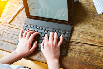 Top view of hands of a teen female doing her school work while indoors - Covid-19- Indoors - Concept Homeschool