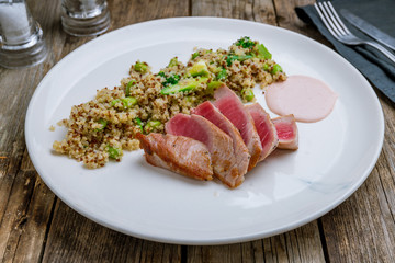 grilled tuna fillet with Salmon quinoa on wooden table