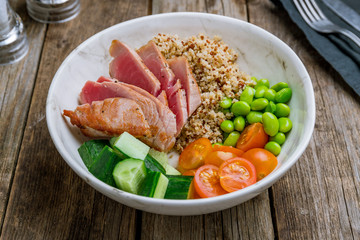 Ahi poke with tuna and quinoa on wooden table