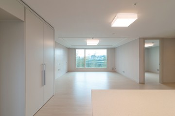 Empty living room interior of a new apartment seen from the kitchen. 
New apartment interior in South Korea.