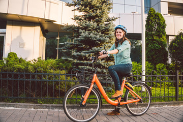 Attractive Friendly Young Woman With Her Bicycle. Portrait of young woman on the street with bicycle. ecological bicycle transport. Student girl came to study at the college on a rental bicycle