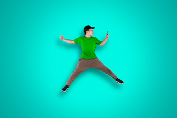 Fototapeta na wymiar Young dancer jumping with smartphone