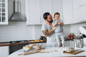 happy family in the kitchen. father and son preparing the dough, bake cookies