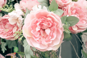 Large pink artificial peonies flowers on the wall. Delicate floral texture background for wedding scene, festive decor.