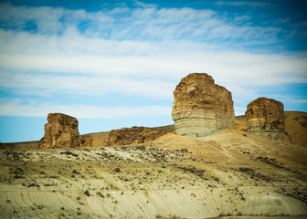 Fototapeta premium Cliffs Rising Out of the Southwestern Desert with Blue Sky and White Clouds