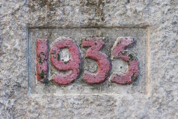 Old concrete bas-relief on the wall, numer 1935