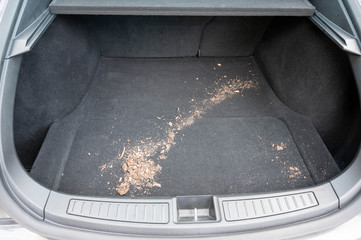 Dirt spilled in rear of car trunk. The carpet is diry.