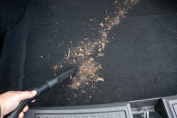 Closeup of a vacuum in the trunk of car cleaning up spilled dirt