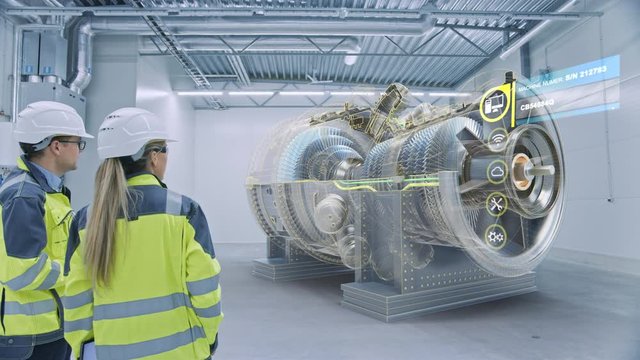 Industry 4.0: Two Engineers Standing, Talking in Factory Workshop with Augmented Reality 3D Model Engine, Analysing Components, Fuel Use Efficiency. VFX Special Visual Effects, Graphics Visualization