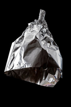 Conspiracy theories, mad pseudoscience and humorous joke concept with tin foil hat isolated on black background with clipping path cutout using ghost mannequin technique
