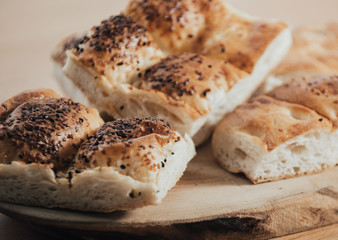 Turkish Ramadan Bread - Ramazan Pidesi on wooden table with yellow background. Popular food in Ramadan. Homemade pie.