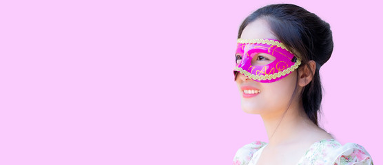 Banner of Asia girl wearing carnival mask on pink background