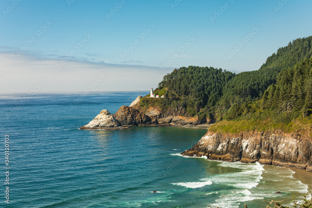 Wall mural beach and cliffs leading to heceta head lighthouse as seen from overlook with fog bank offshore.