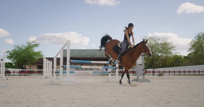 Girl horseback riding in equestrian course