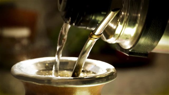 Traditional Argentinian hot drink prepared with Yerba Mate and served in a container made with a pumpkin