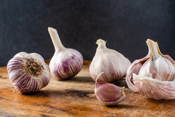 Whole garlic bulbs and clove, selective focus, close up, copy space, dark background