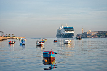 view of cruise ship entering havana bay with lighthouse and boats in the background - 340124105