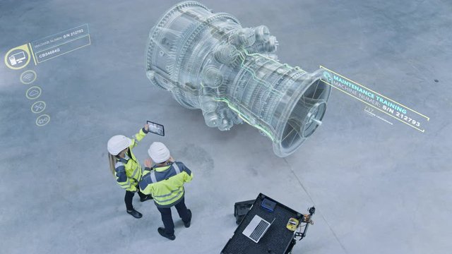 Industry 4.0 Factory: Two Engineers Uses Digital Tablet Computer with AR Software to Connect with High-Tech CNC Machinery and Visualize Maintenance and Diagnostics of the Equipment. Elevated Shot