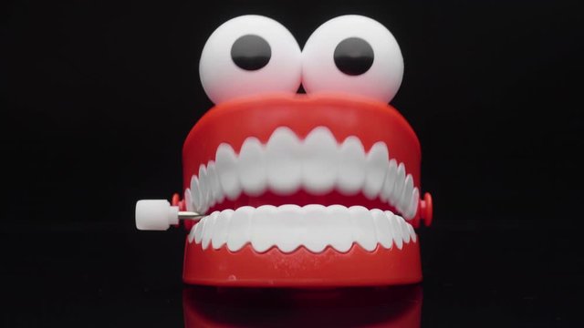 Сhattering teeth toy moving on black background.