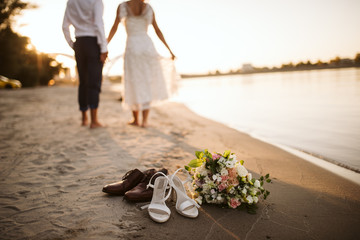 The bride's and the groom's feet in the sand on the beach