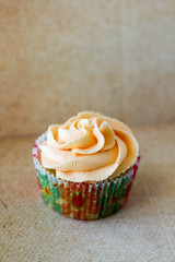 Vanilla cupcakes with colorful liners and sprinkles on display