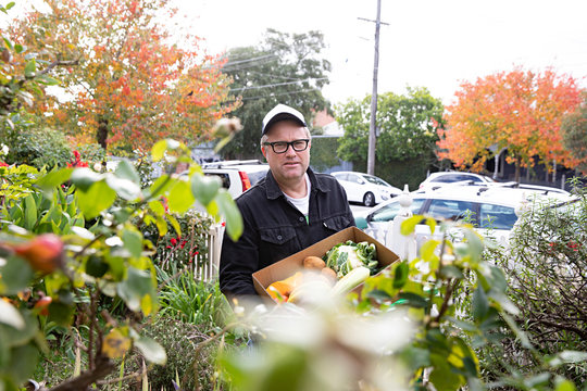 A man delivers fresh fruit and vegetables to houses