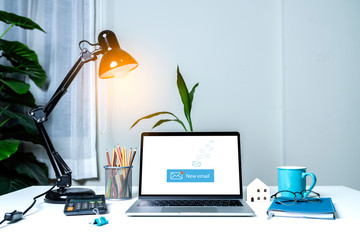 Laptop computer on white table with email communication connection message online and chat on social media with global letters concept. Laptop mockup with clipping path on screen.